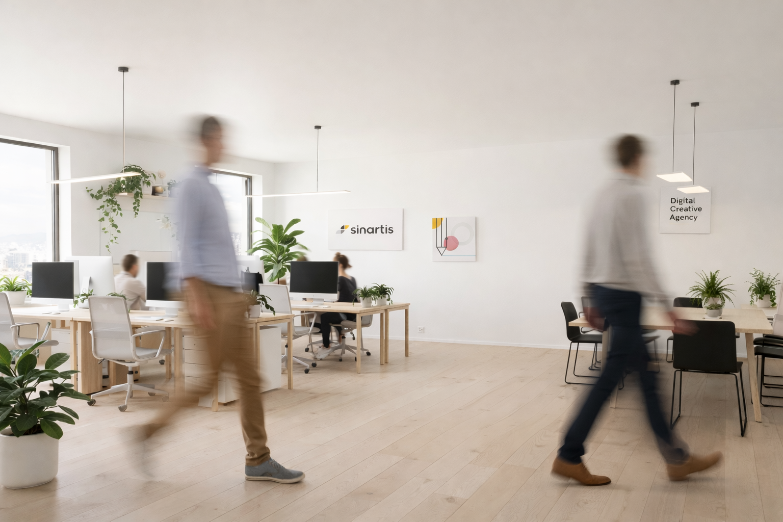 Bureau Sinartis avec collaborateurs marchant, signe Sinartis au mur